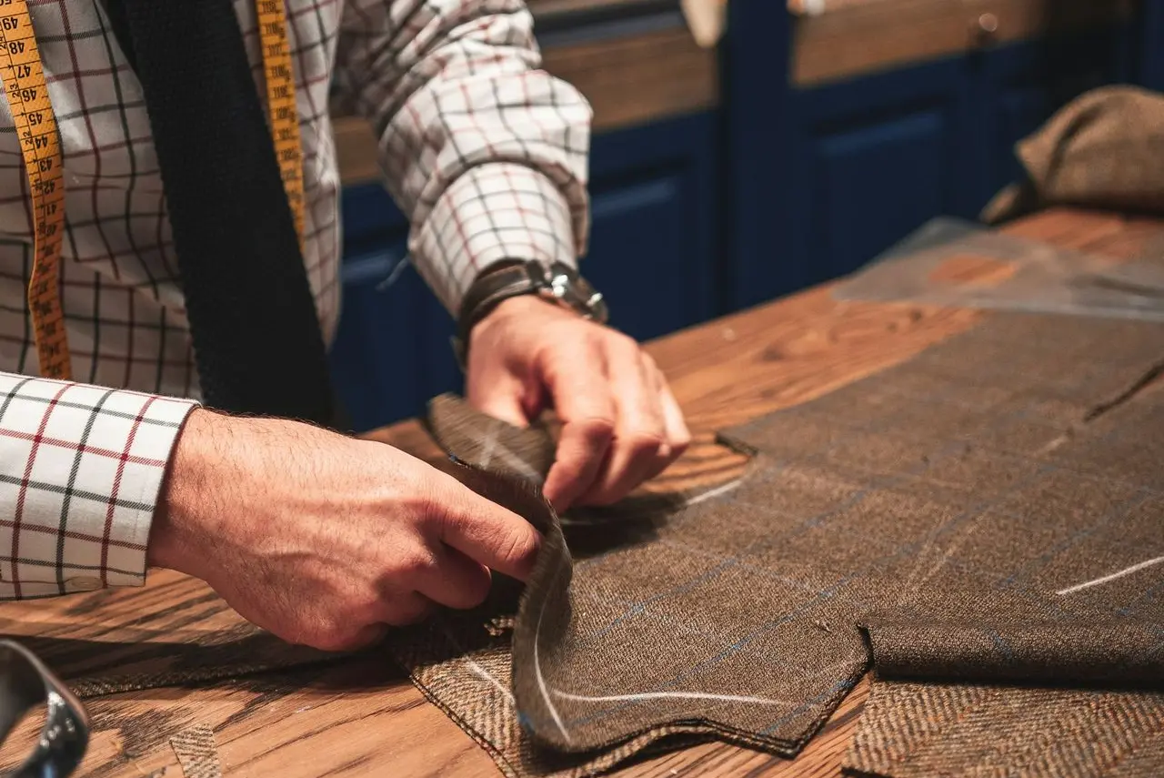 person in black suit holding brown leather bag